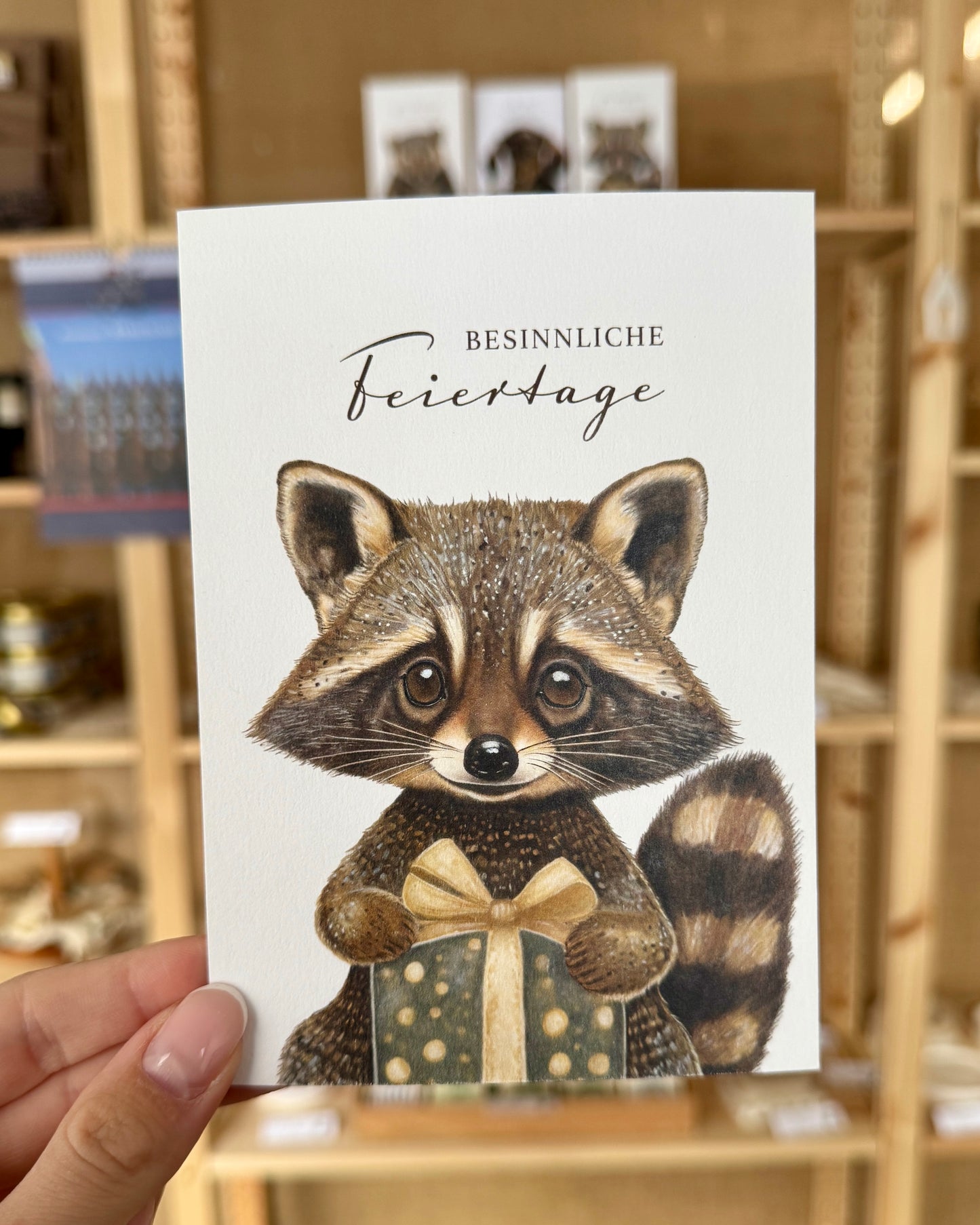 Weihnachten: Postkarte „Waschbär mit Geschenk“
