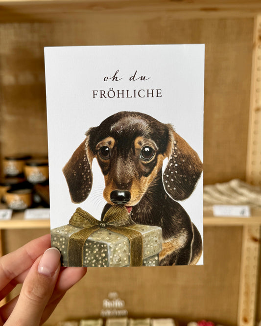 Weihnachten: Postkarte „Dackel mit Geschenk“